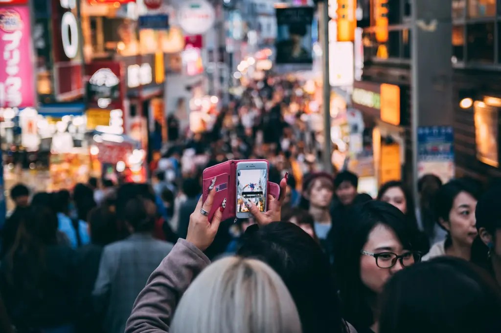 A foreign tourist taking a photo at a popular attraction, symbolizing Busan’s growing appeal to international visitors