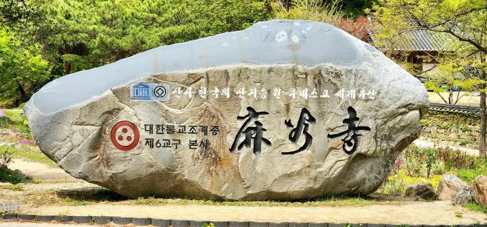 Stone monument marking Magoksa Temple’s UNESCO heritage status in Gongju, South Korea, surrounded by spring greenery.