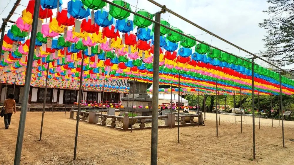 A colorful lantern canopy suspended above the stone pagoda in the courtyard of Magoksa Temple in Gongju, South Korea.