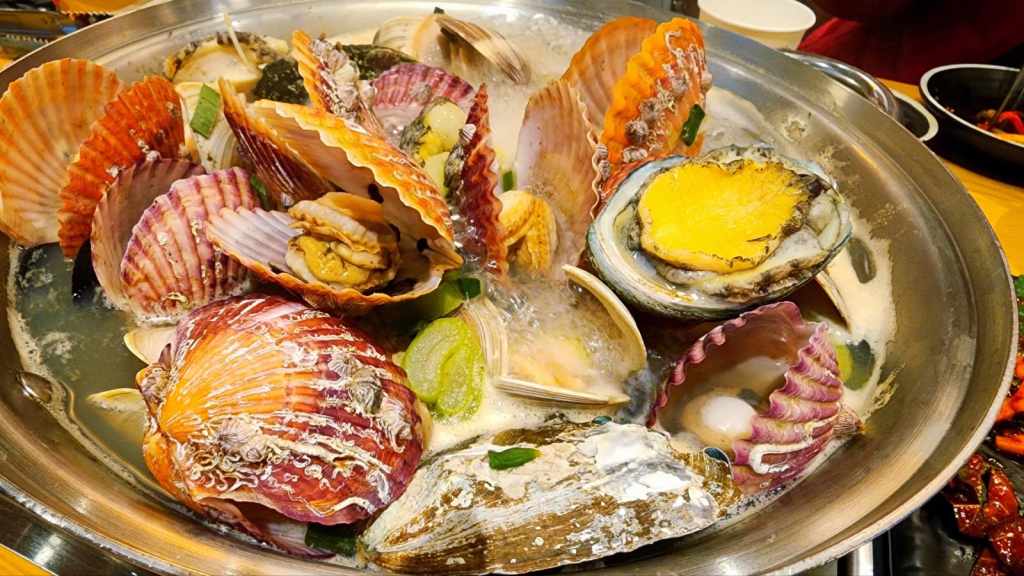 해물탕 (Haemultang), a Korean seafood hot pot with abalone, clams, and vegetables in rich broth