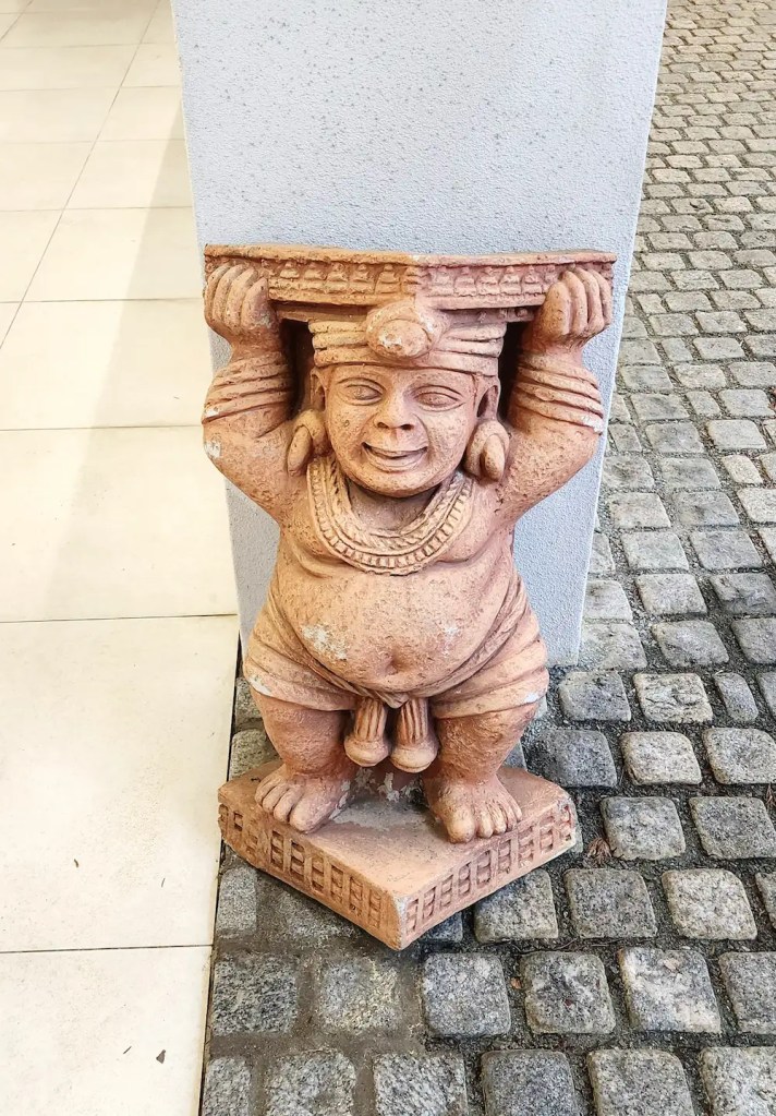 A terracotta Yaksha statue placed outside Bhavan, inspired by ancient Indian guardian figures.