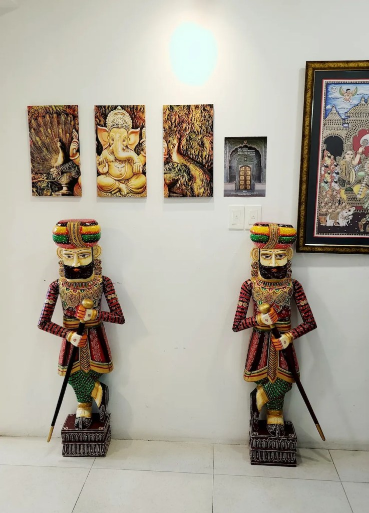 Two traditional Indian statues with detailed wall paintings at Bhavan, an Indian restaurant in Daeyeon, Busan.