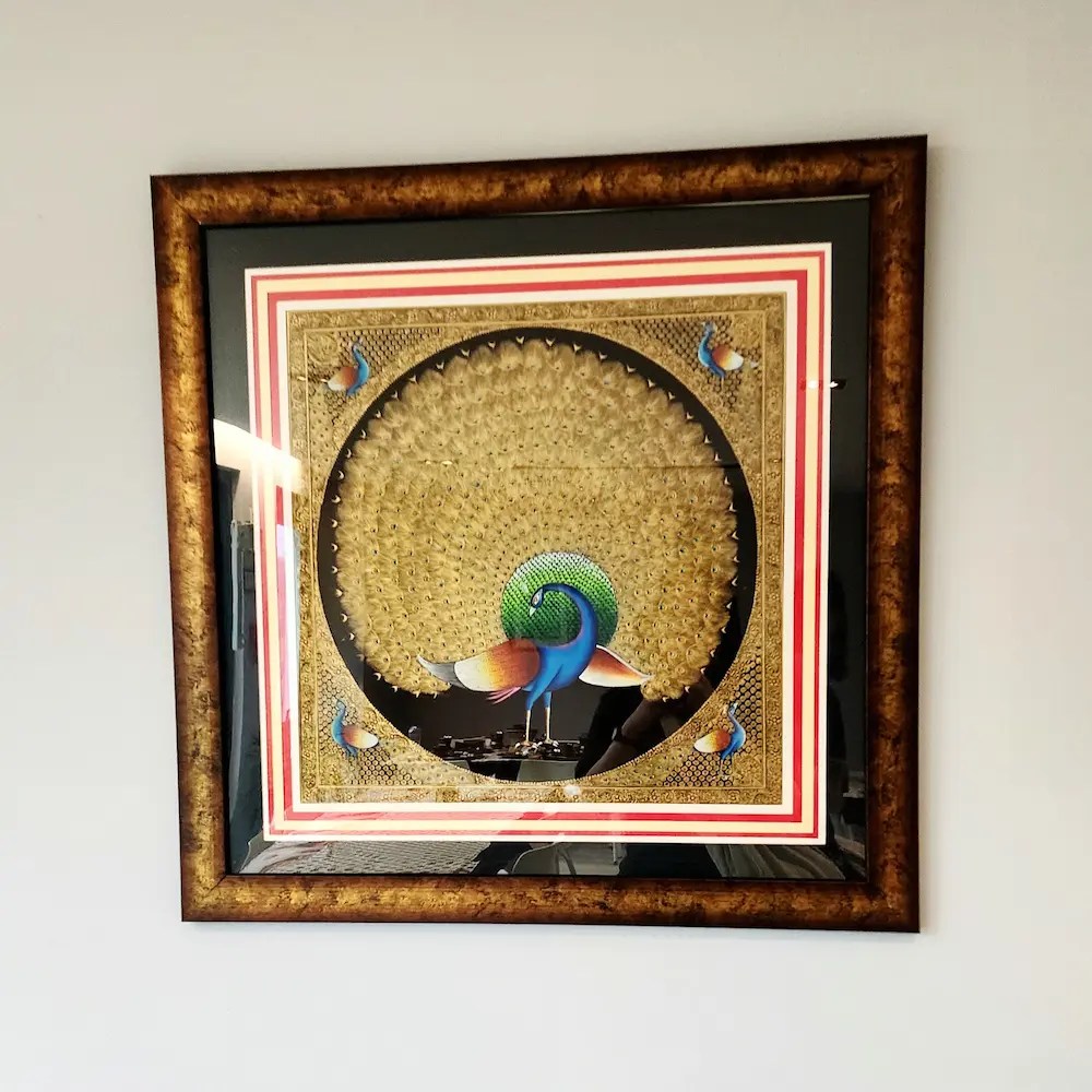 Golden frame with traditional Indian painting inside
/ Cadre doré avec une peinture traditionnelle indienne