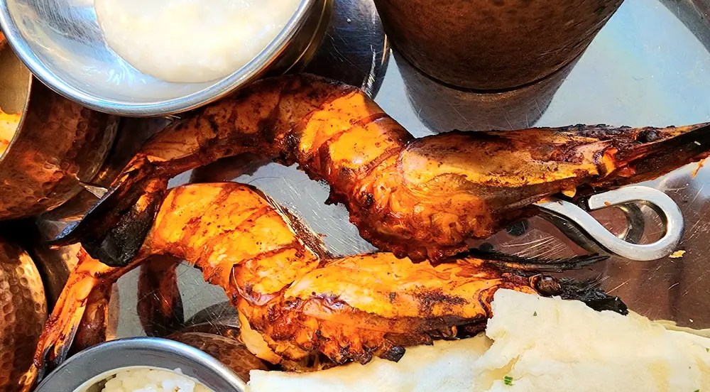 Spicy grilled shrimp served on a traditional Indian thali