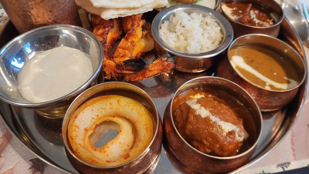 South Indian Thali set with rice, grilled shrimp, curries, and desserts