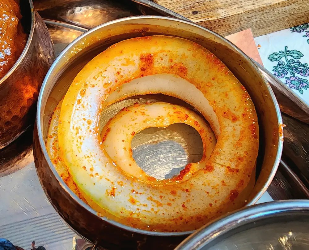 Spiced onion rings served in a small copper bowl