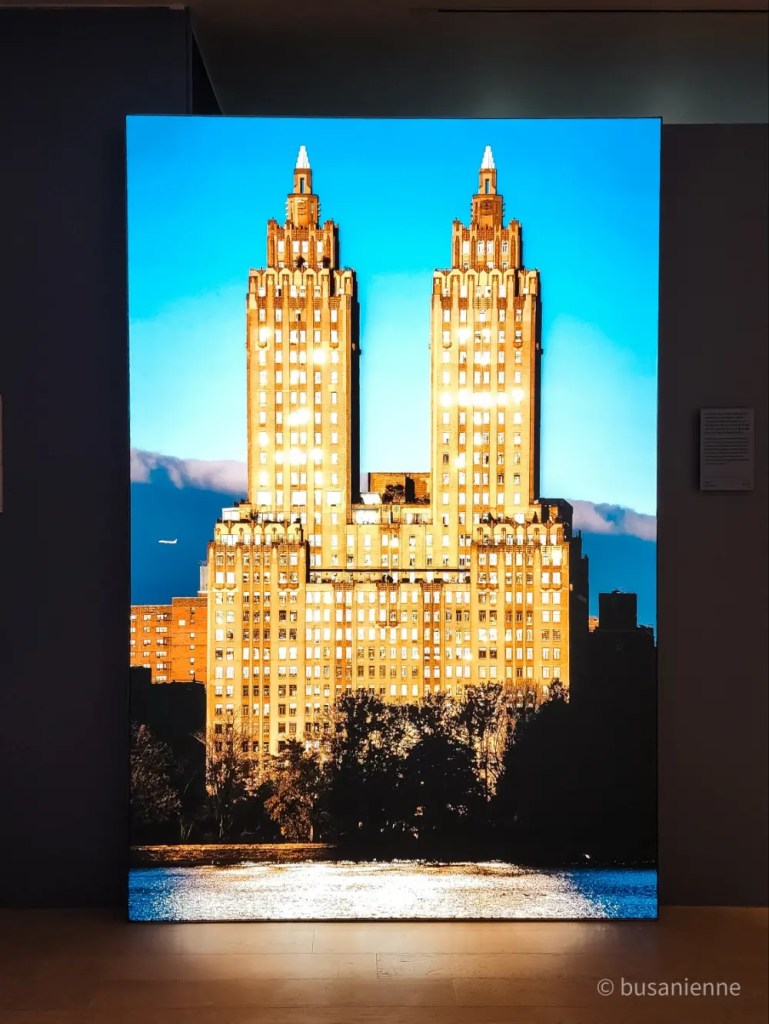 Illuminated New York skyscraper captured at sunset, part of Kyungjun Lee’s “One Step Away” photo exhibition in Busan 2025