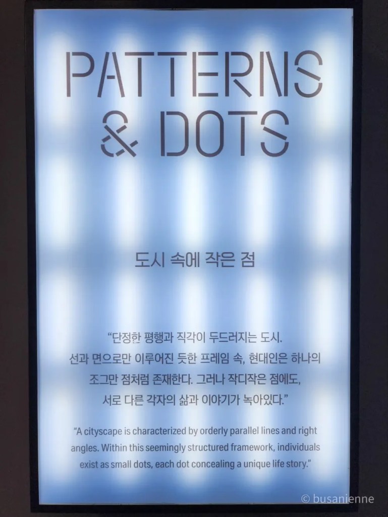 Introductory concept panel from the “One Step Away” photo exhibition by Kyungjun Lee, titled “Patterns & Dots,” explaining cityscapes as small dots with unique stories