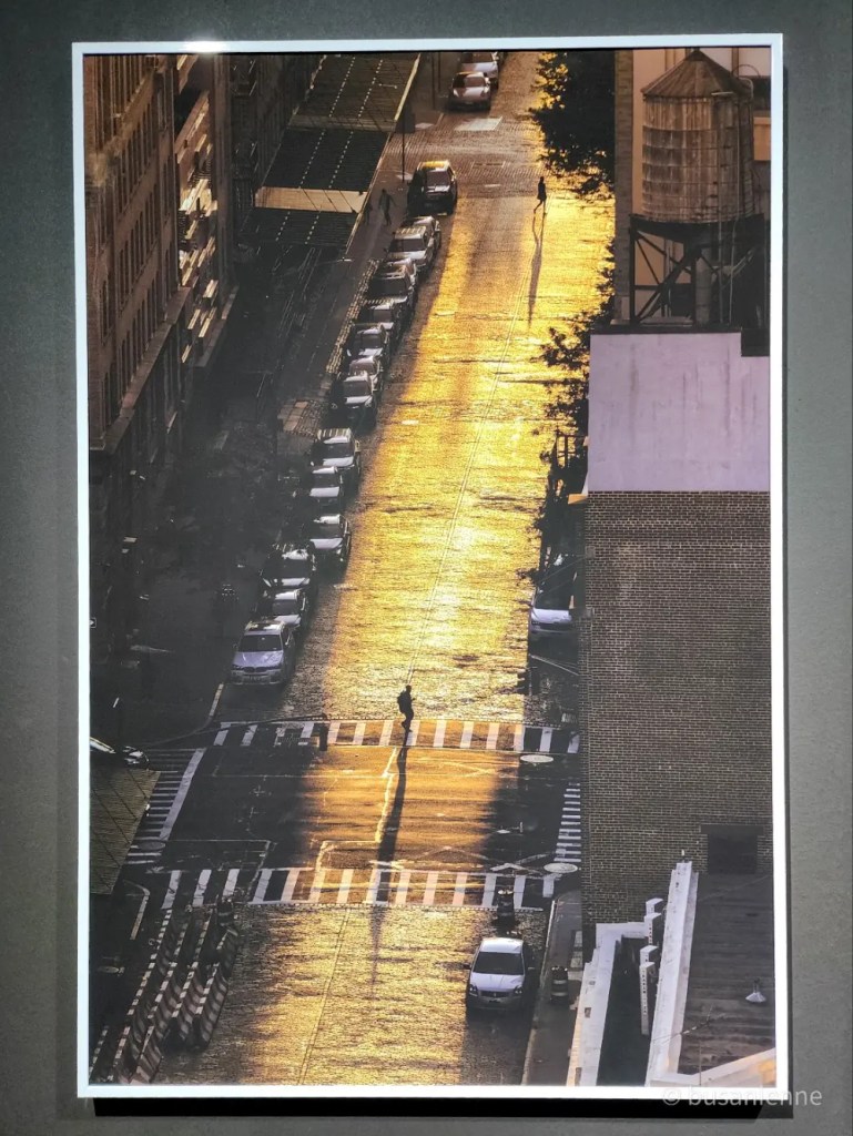 Rue de New York illuminée par une lumière dorée avec des silhouettes de passants et leurs ombres allongées