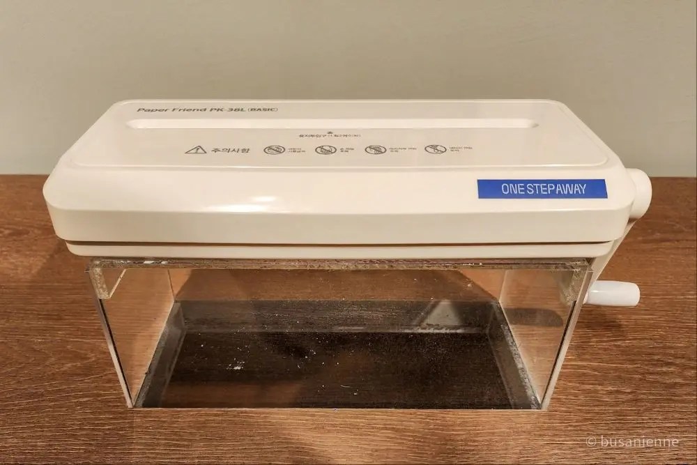 White paper shredder labeled One Step Away, part of an interactive exhibition where visitors shred written worries.