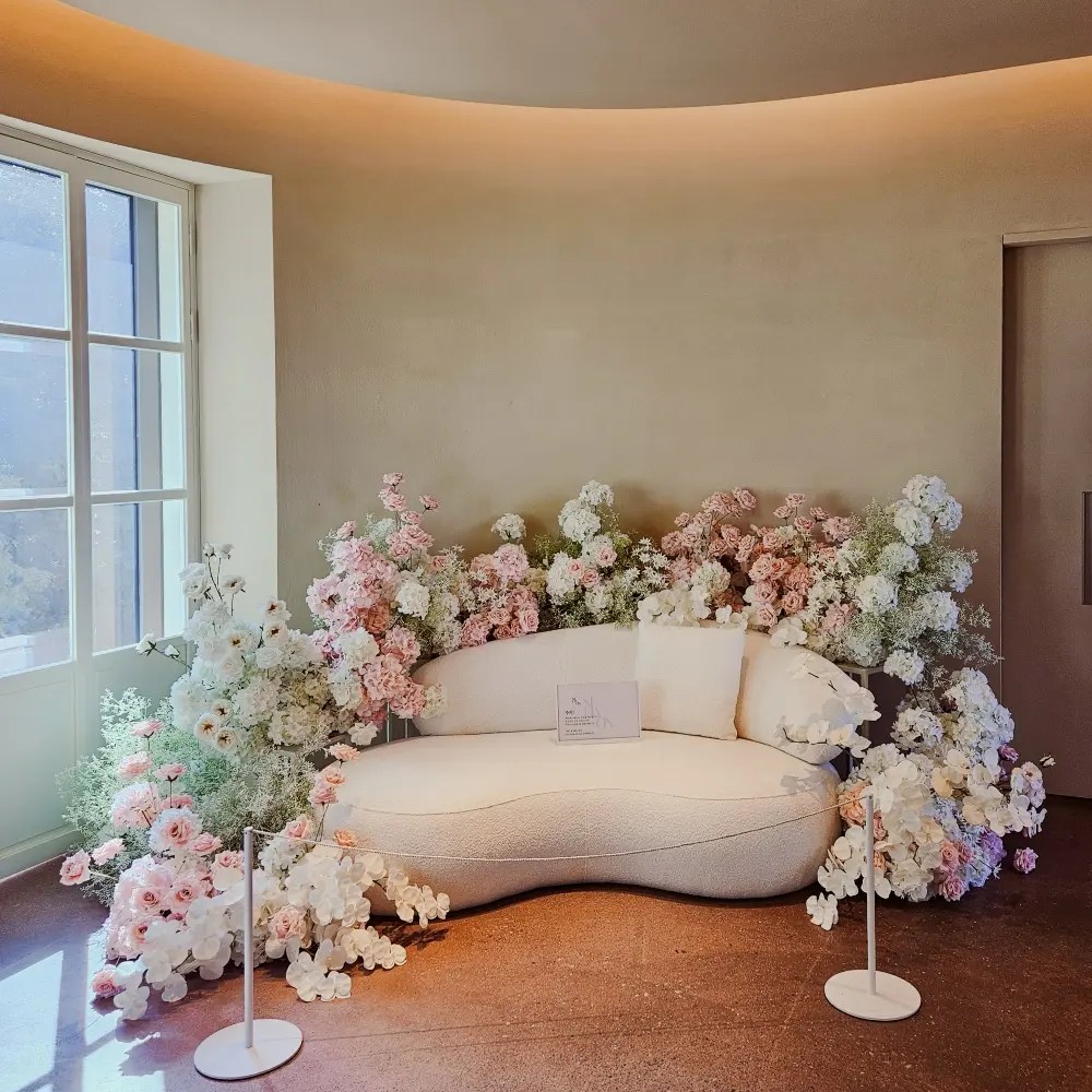 Cream sofa surrounded by pastel floral arrangement in a sunlit room at Sihaon Café in Ulsan.