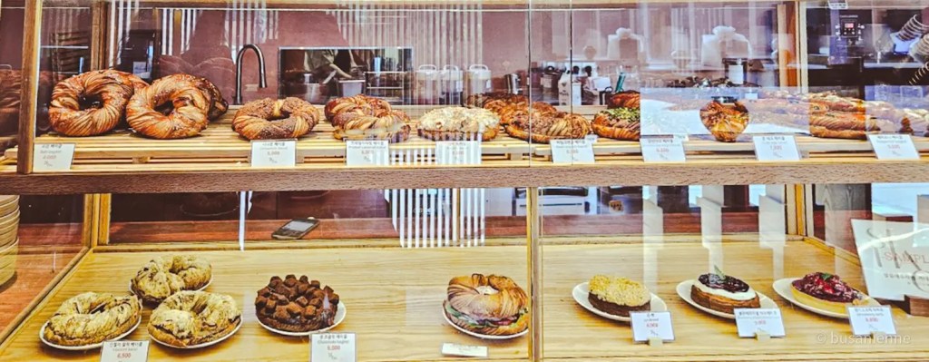 Bakery display case with croissants, fruit tarts, and chocolate desserts at Sihaon Café in Ulsan.